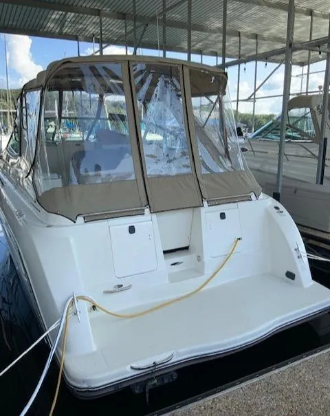 Slide: The Image of 2000 Maxum 3300 SCR boat docked with tan canopy and clear windows. - 5