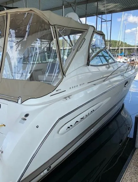 Slide: The Image of 2000 Maxum 3300 SCR boat docked in a marina with beige canopy. - 8