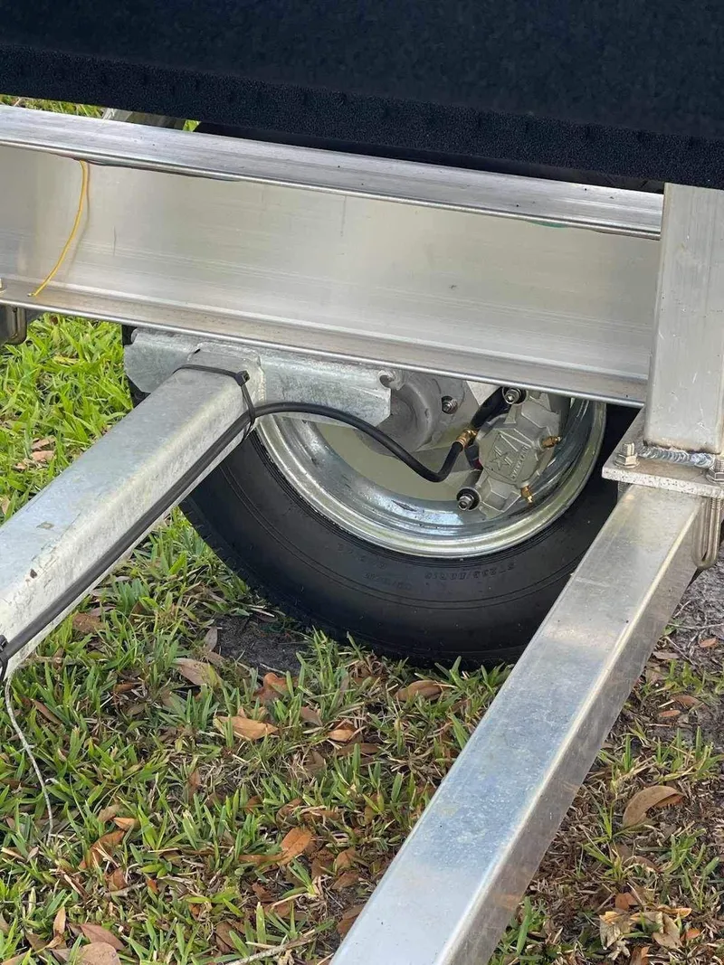 Slide: The Image of Trailer wheel of 2000 Glacier Bay 260 Canyon Runner on grass. - 19