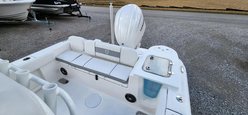Slide: The Image of 2024 Sea Fox 248 Commander boat interior with seating and motor, parked on gravel. - 7