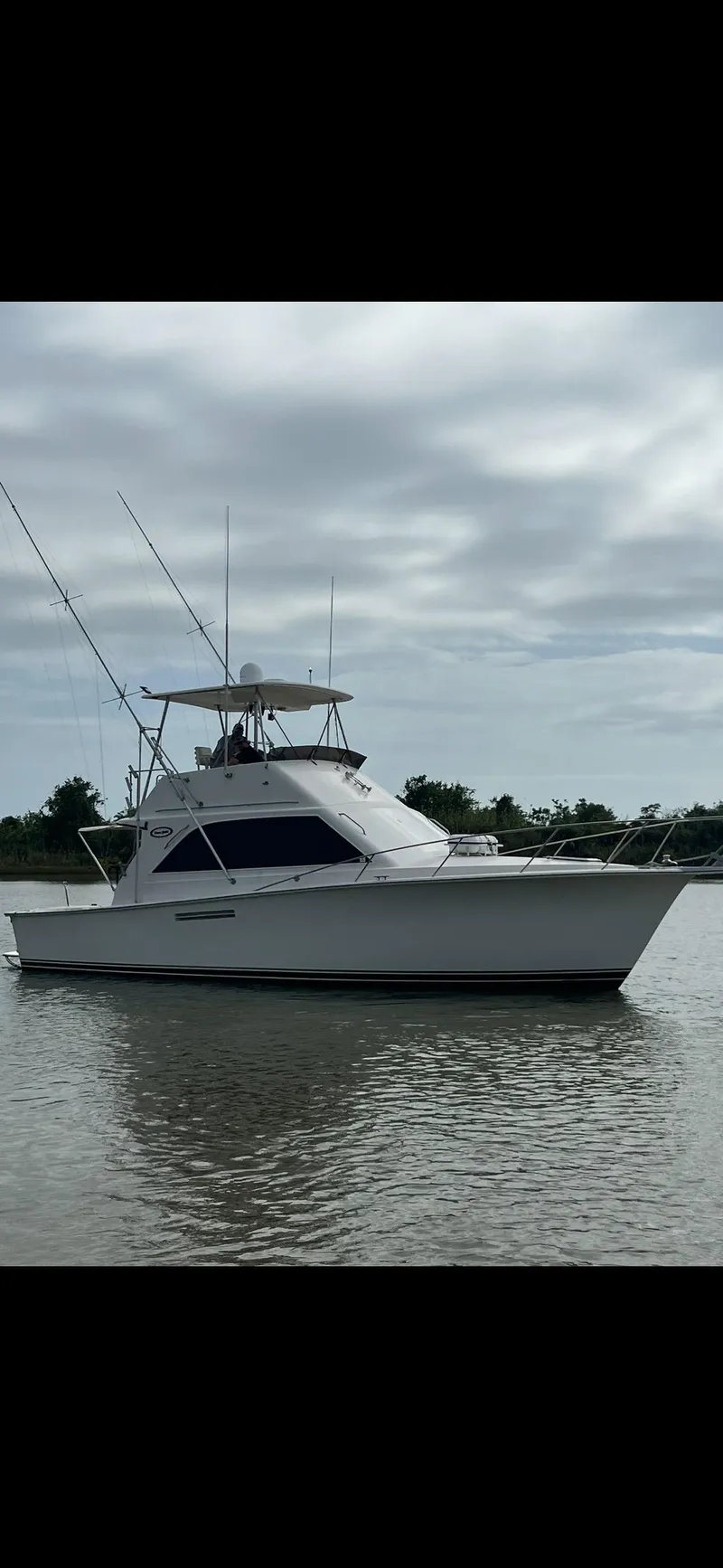 Slide: The Image of 1985 Ocean 38 Super Sport boat on calm water. - 14