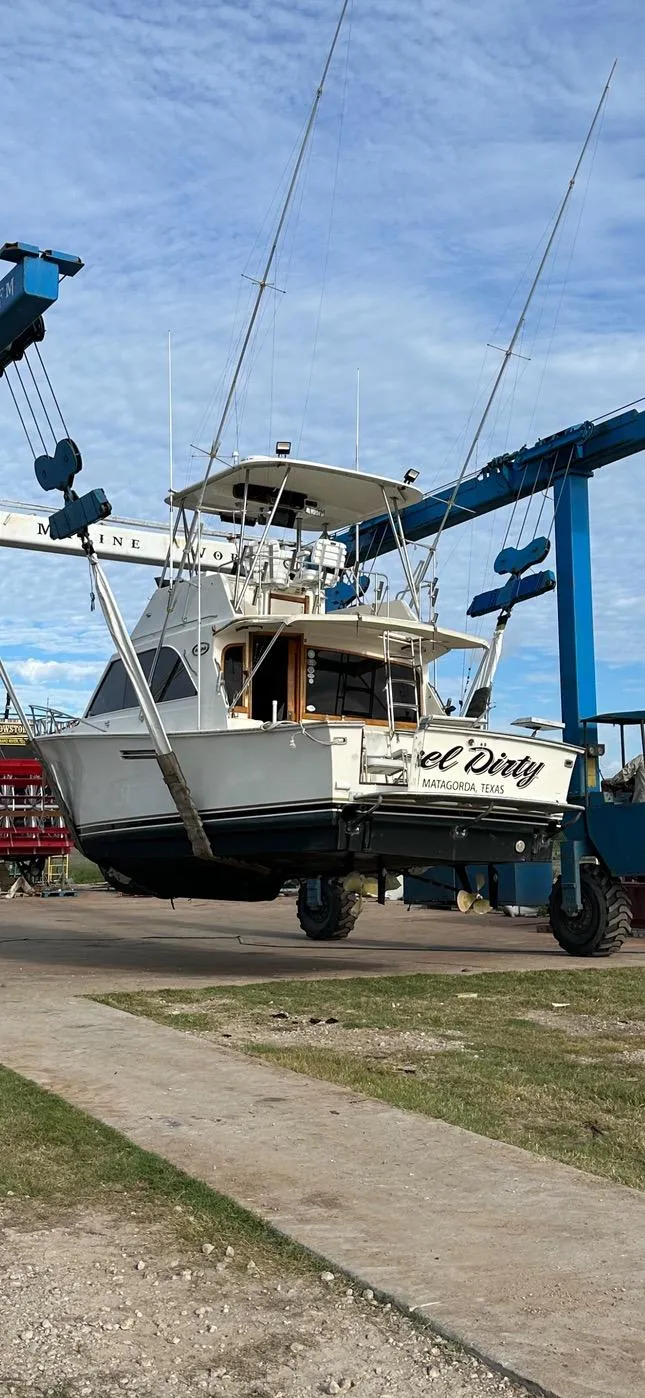 Slide: The Image of 1985 Ocean 38 Super Sport boat being lifted by a crane. - 16
