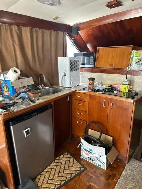 Slide: The Image of 1985 Ocean 38 Super Sport boat kitchen with wooden cabinets and appliances. - 21
