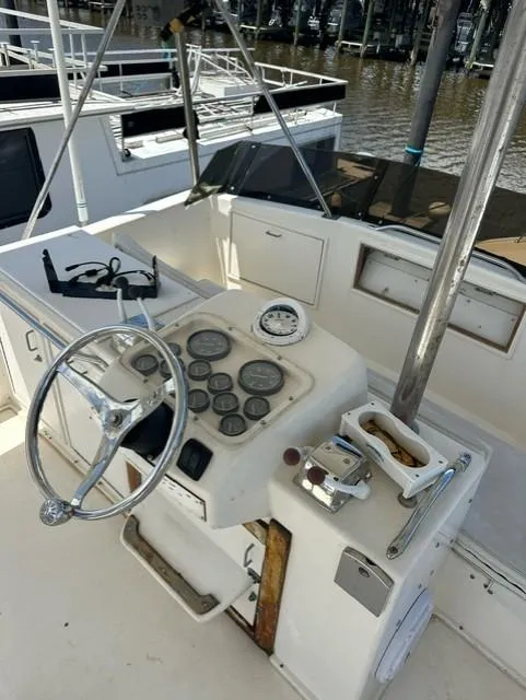 Slide: The Image of 1985 Ocean 38 Super Sport boat helm with steering wheel and gauges. - 23