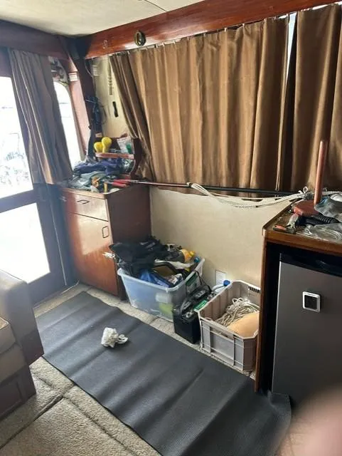 Slide: The Image of Interior of 1985 Ocean 38 Super Sport boat with storage bins and brown curtains. - 24