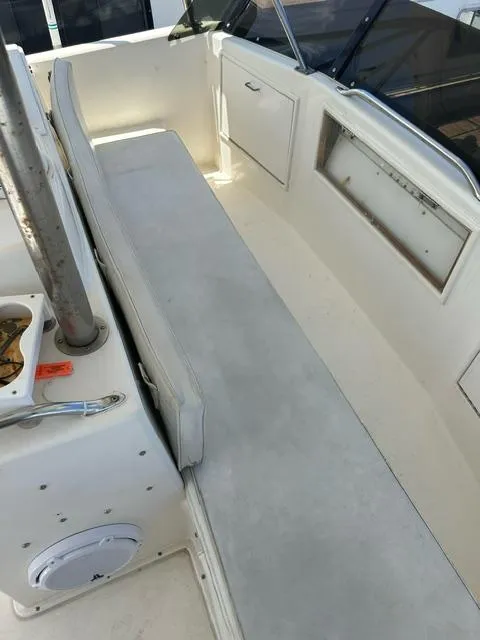 Slide: The Image of 1985 Ocean 38 Super Sport boat interior with white seating and storage compartments. - 29