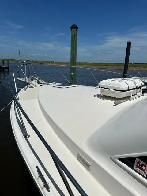 Slide: The Image of 1985 Ocean 38 Super Sport boat docked by the water on a sunny day. - 37