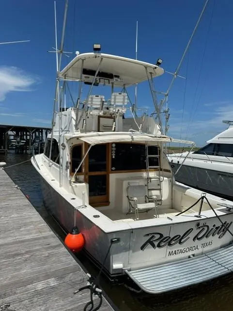 Slide: The Image of 1985 Ocean 38 Super Sport docked, rear view with Reel Dirty name and Matagorda, Texas location. - 4