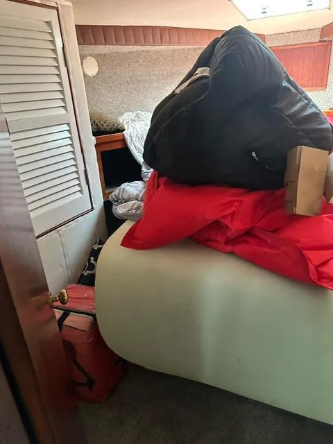 Slide: The Image of Interior cabin of a 1985 Ocean 38 Super Sport boat with cluttered bedding. - 42