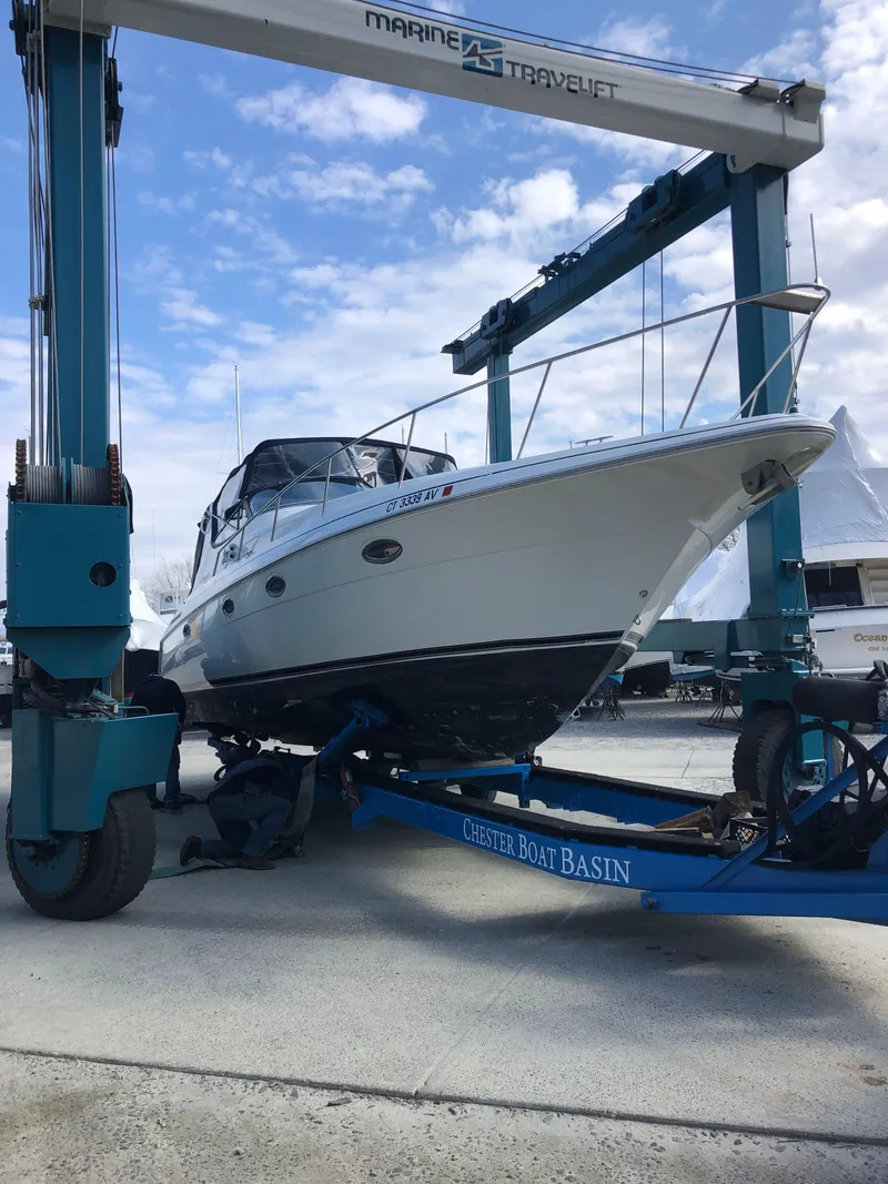 Slide: The Image of 2000 Cruisers Yachts 3375 Express on a boat lift at a marina. - 3