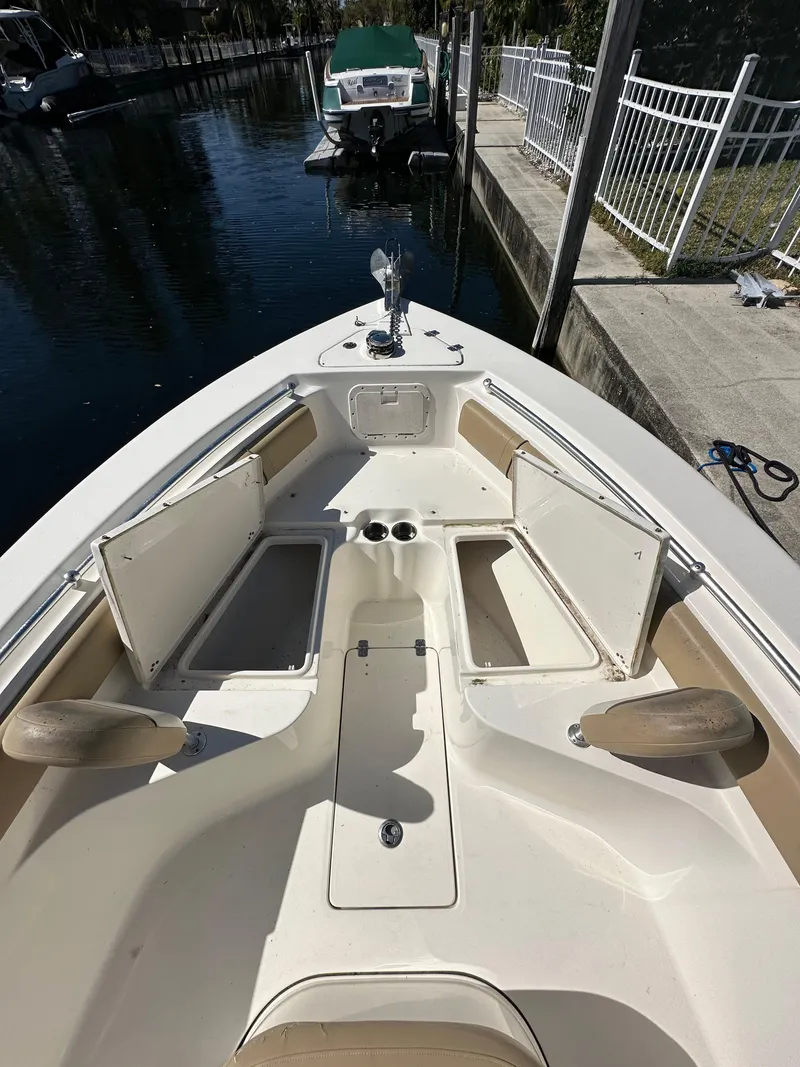 Slide: The Image of 2019 Key West 239 FS boat bow with open storage compartments docked by a canal. - 23
