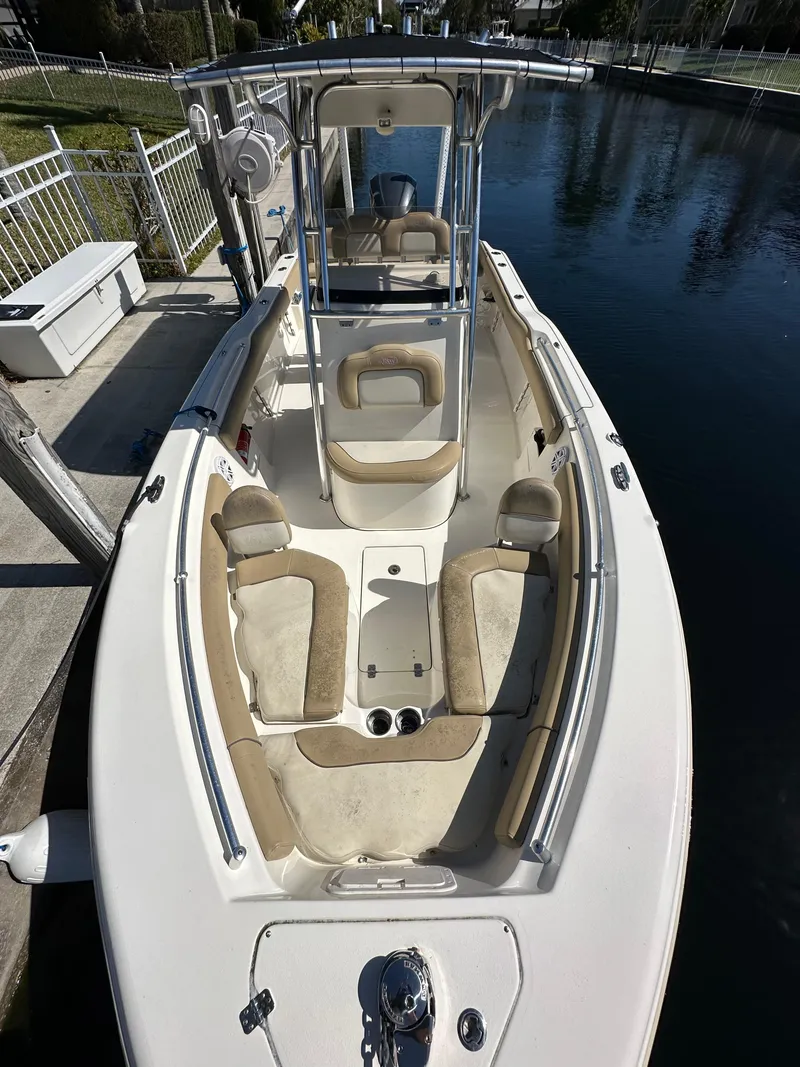 Slide: The Image of 2019 Key West 239 FS boat docked by a canal, featuring spacious seating and a center console. - 29