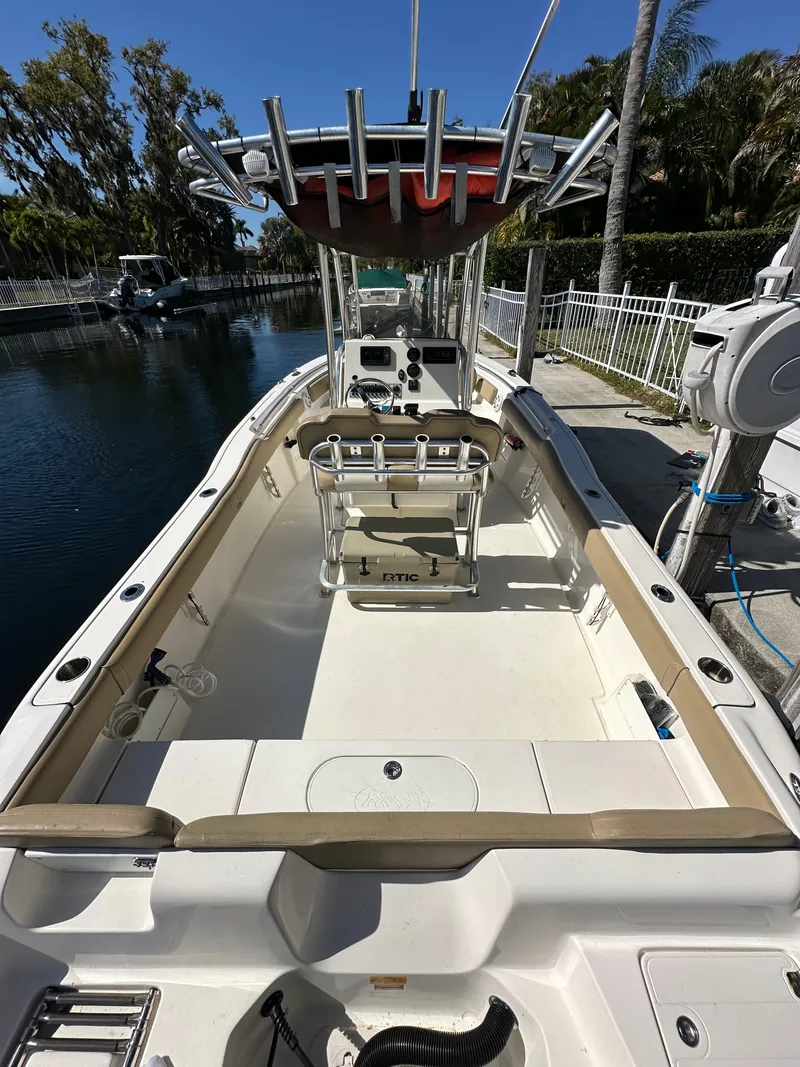 Slide: The Image of 2019 Key West 239 FS boat docked near a canal, featuring spacious seating and fishing rod holders. - 7