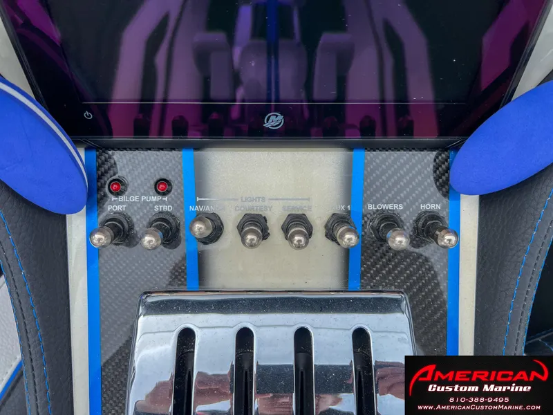Slide: The Image of Control panel of a 2022 MTI 390X boat with various switches. - 36