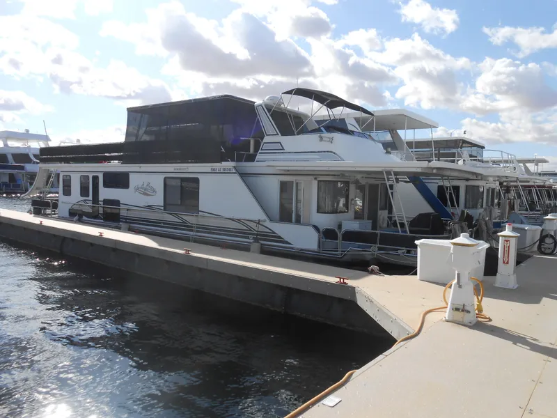 The Image of Sumerset 7016 houseboat, year 2000, docked at a marina under a partly cloudy sky. - 0