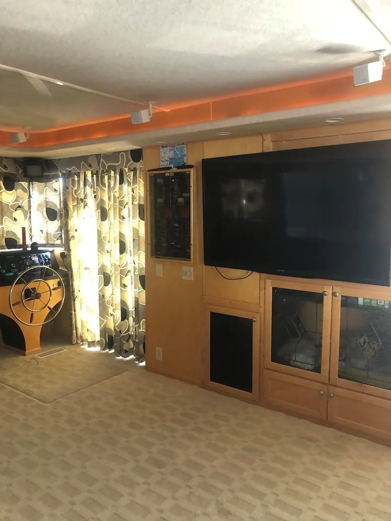 Slide: The Image of Interior of 2000 Sumerset 7016 houseboat with TV and patterned curtains. - 15