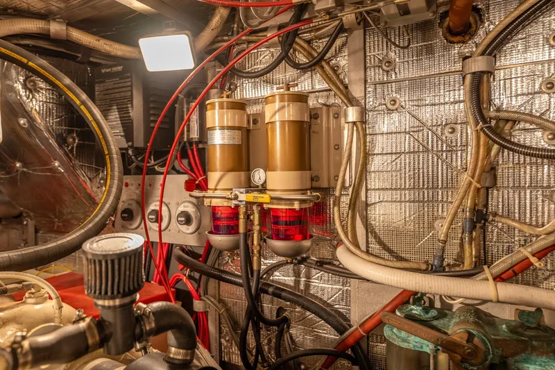 Slide: The Image of Engine room of 1999 Rozema Boat Works Custom 40, showcasing complex wiring and components. - 29