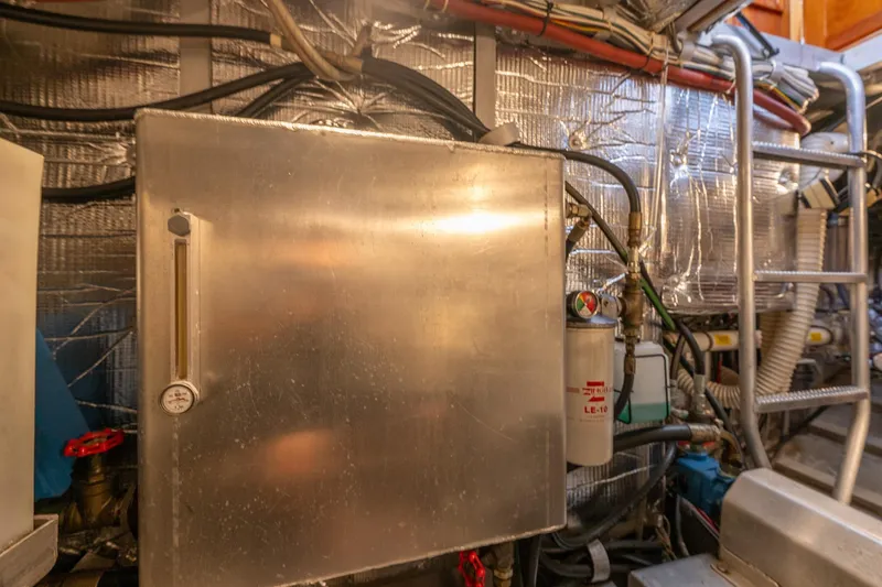 Slide: The Image of Engine room of 1999 Rozema Boat Works Custom 40, featuring metal panel and equipment. - 30