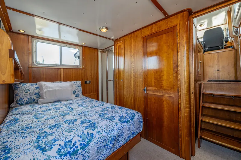 Slide: The Image of Cozy cabin interior of 1999 Rozema Boat Works Custom 40 with wooden finishes and floral bedding. - 4