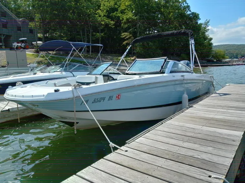 Slide: The Image of 2022 Four Winns HD2 boat docked at a lakeside marina. - 0