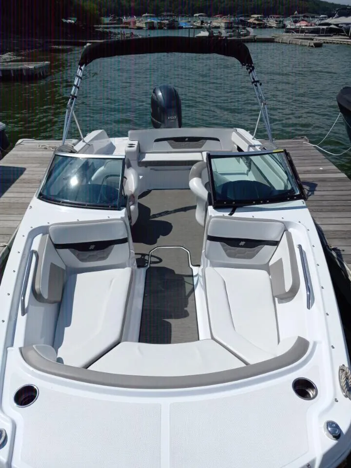 Slide: The Image of 2022 Four Winns HD2 boat docked, showcasing spacious seating and sleek design. - 6