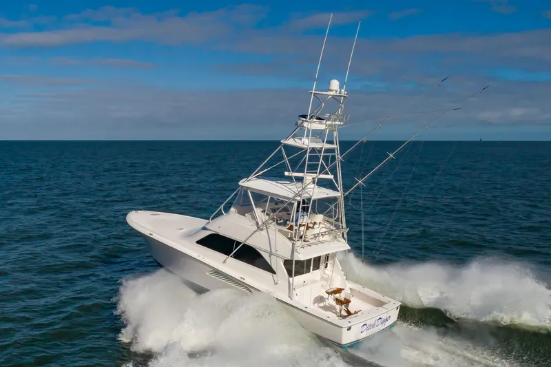 Slide: The Image of 2005 Viking Convertible yacht cruising on open sea under clear blue sky. - 10
