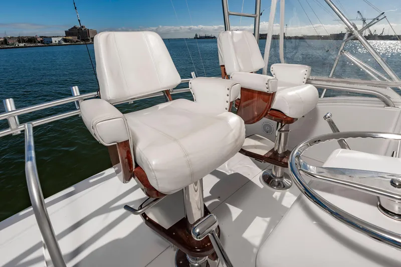 Slide: The Image of Luxury seating on a 2005 Viking Convertible yacht, overlooking a serene waterfront. - 17