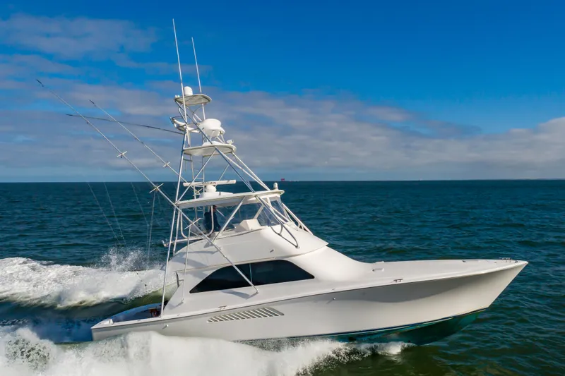 Slide: The Image of 2005 Viking Convertible yacht cruising on open sea under clear blue sky. - 2