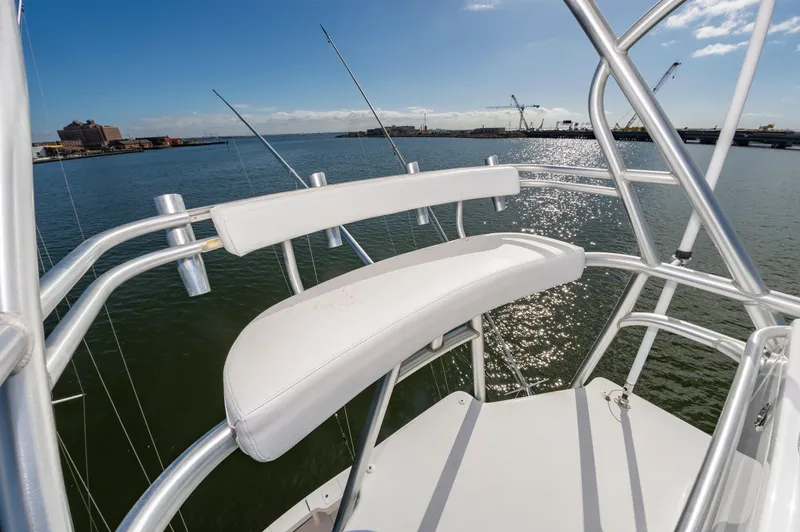 Slide: The Image of 2005 Viking Convertible boat's upper deck with white seating and ocean view. - 22