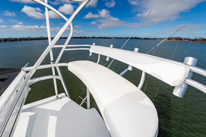 Slide: The Image of 2005 Viking Convertible boat deck with white seating, overlooking calm water and blue sky. - 24