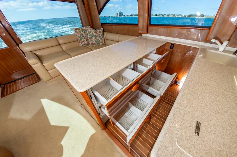 Slide: The Image of Luxurious 2005 Viking Convertible yacht interior with open drawers, beige seating, and ocean view. - 35