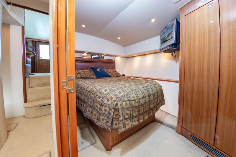 Slide: The Image of Luxurious bedroom interior of 2005 Viking Convertible yacht with cozy bed and wooden accents. - 38