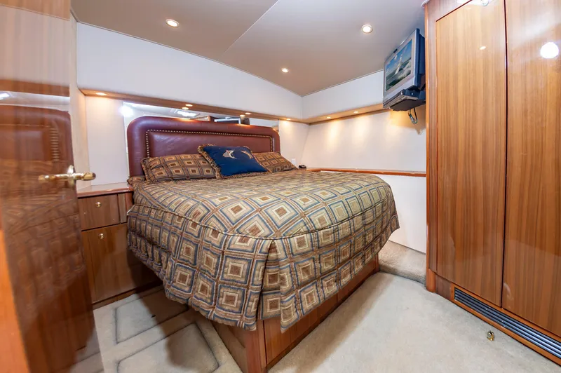 Slide: The Image of Luxurious bedroom interior of a 2005 Viking Convertible yacht with elegant wood finishes. - 39