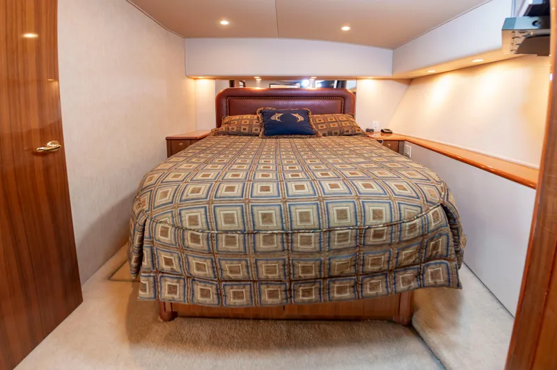 Slide: The Image of Luxurious bedroom interior of a 2005 Viking Convertible yacht with patterned bedding. - 40