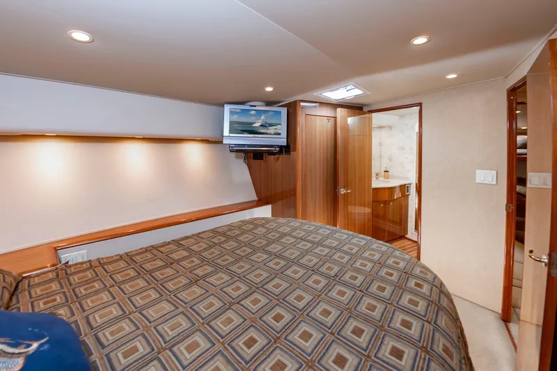Slide: The Image of Luxurious bedroom interior of 2005 Viking Convertible yacht with patterned bedding and wall-mounted TV. - 41