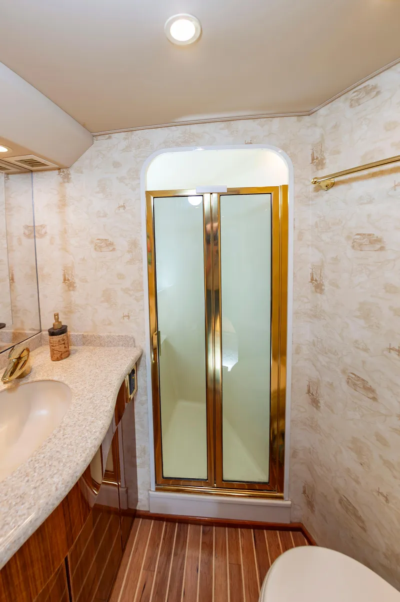 Slide: The Image of Luxurious bathroom in 2005 Viking Convertible yacht with gold-trimmed shower and elegant fixtures. - 44