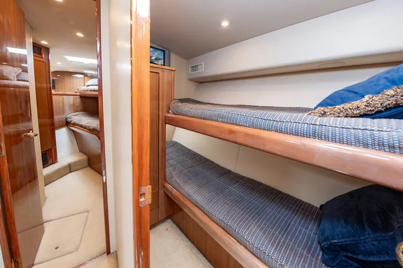 Slide: The Image of Interior of 2005 Viking Convertible yacht with cozy bunk beds and wooden finishes. - 49