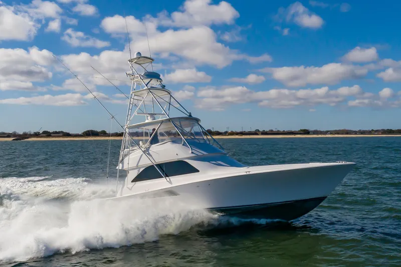 Slide: The Image of 2005 Viking Convertible yacht cruising on open water under a blue sky. - 5