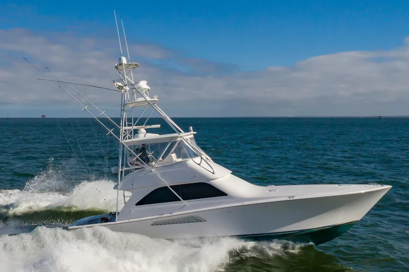 Slide: The Image of 2005 Viking Convertible yacht cruising on open sea with blue sky background. - 8
