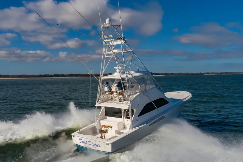 Slide: The Image of 2005 Viking Convertible yacht cruising on open water under a clear blue sky. - 9