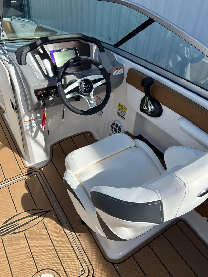 Slide: The Image of 2024 Chaparral 21 Ski & Fish boat cockpit with steering wheel and captain's chair. - 6