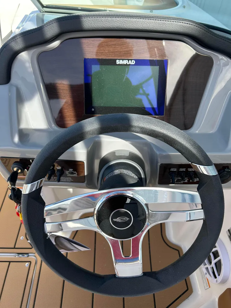 Slide: The Image of 2024 Chaparral 21 Ski & Fish boat dashboard with Simrad display and steering wheel. - 7