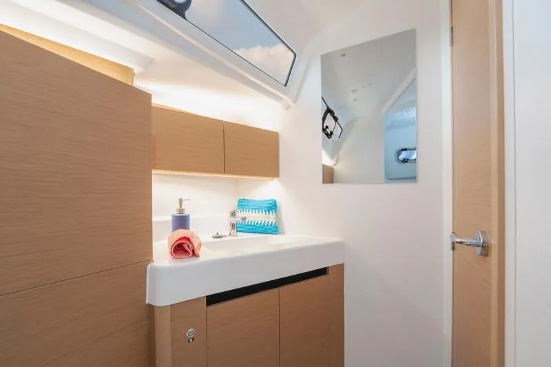 Slide: The Image of Modern bathroom interior of 2025 Jeanneau Sun Odyssey 350 yacht, featuring sleek cabinetry and mirror. - 16