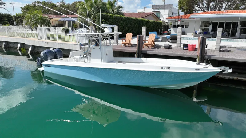 Slide: The Image of 1987 Whitewater 32 Open boat docked near waterfront homes. - 1