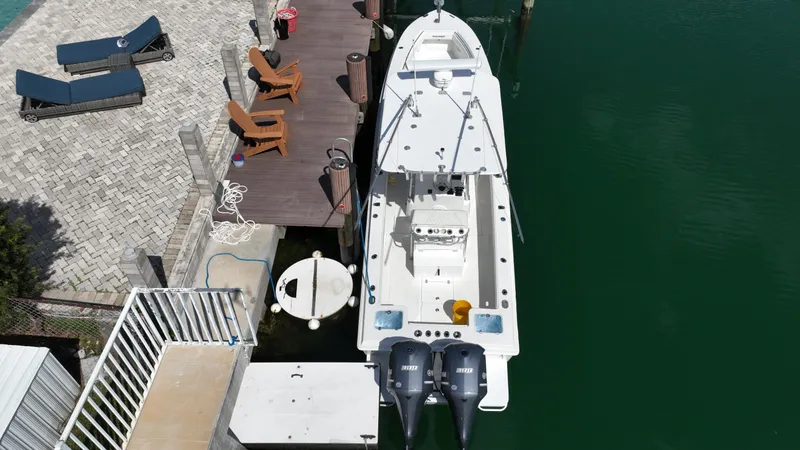 Slide: The Image of Aerial view of a 1987 Whitewater 32 Open boat docked by a waterfront patio. - 4