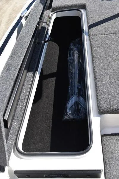 Slide: The Image of 2024 Triton 179 TrX boat storage compartment with carpeted interior. - 11