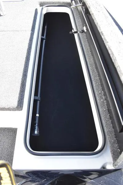 Slide: The Image of 2024 Triton 179 TrX boat storage compartment, open and empty, with carpeted interior. - 13