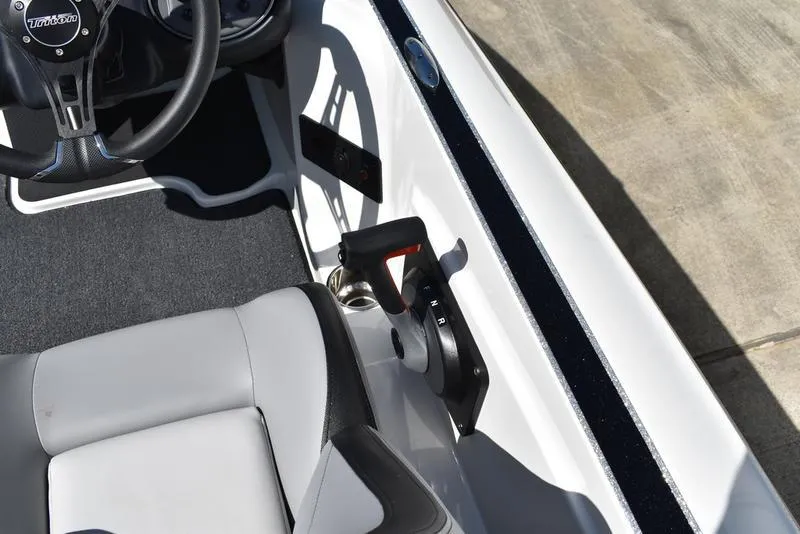 Slide: The Image of 2024 Triton 179 TrX boat interior with steering wheel and throttle control. - 17