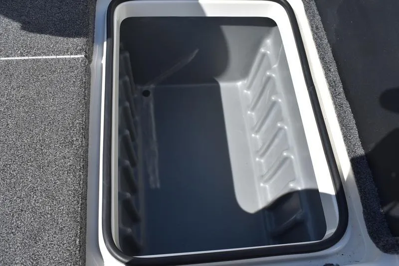 Slide: The Image of 2024 Triton 179 TrX storage compartment with gray interior and textured flooring. - 22