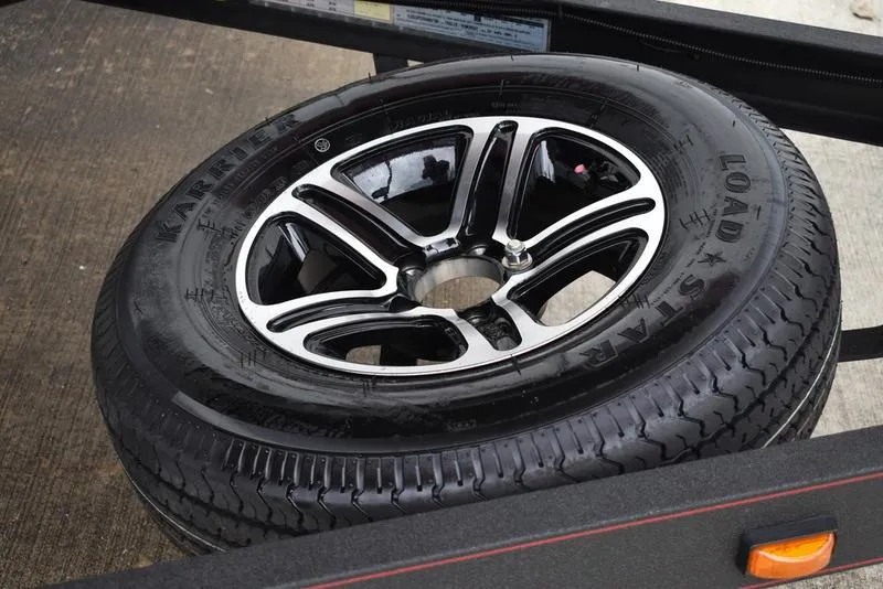 Slide: The Image of Triton 206 Allure 2024 model spare tire with black and silver alloy wheel. - 39